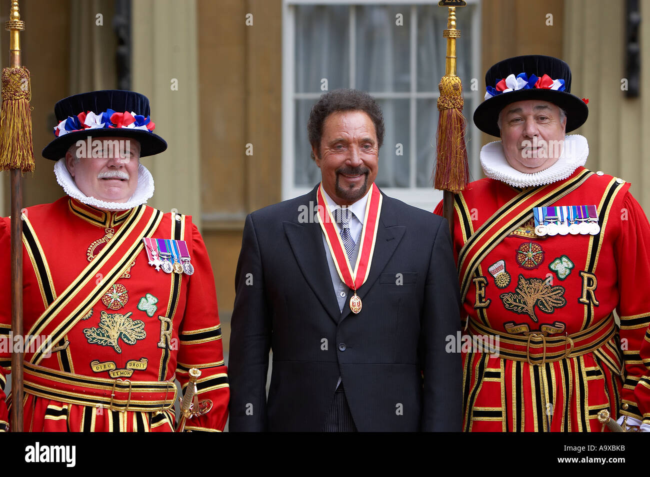 sir tom jones at buckingham palace stands next to 2 beefeaters from th tower of london Stock Photo