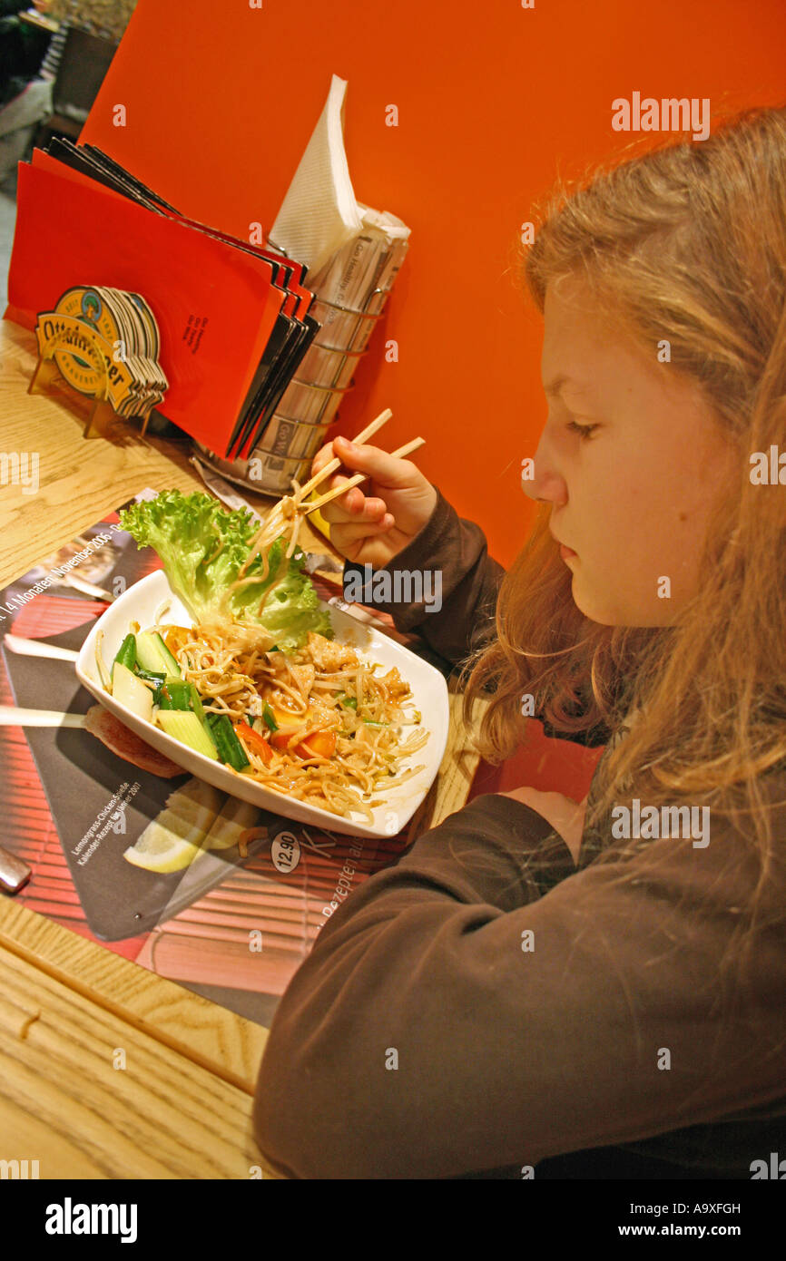 girl eating with chopsticks in china restaurant Stock Photo Alamy