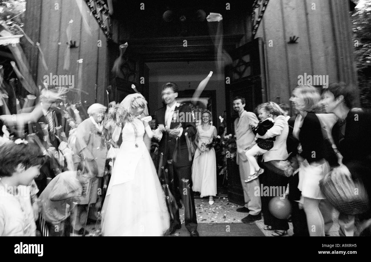 Poland, Lodz, guests throwing rice at bride and groom (B&W) Stock Photo