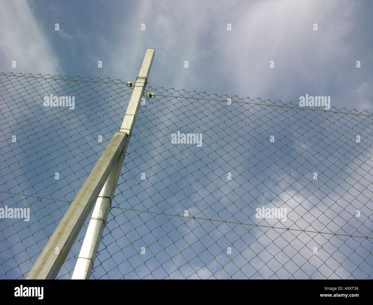 A wired fence against a background of blue sky Stock Photo