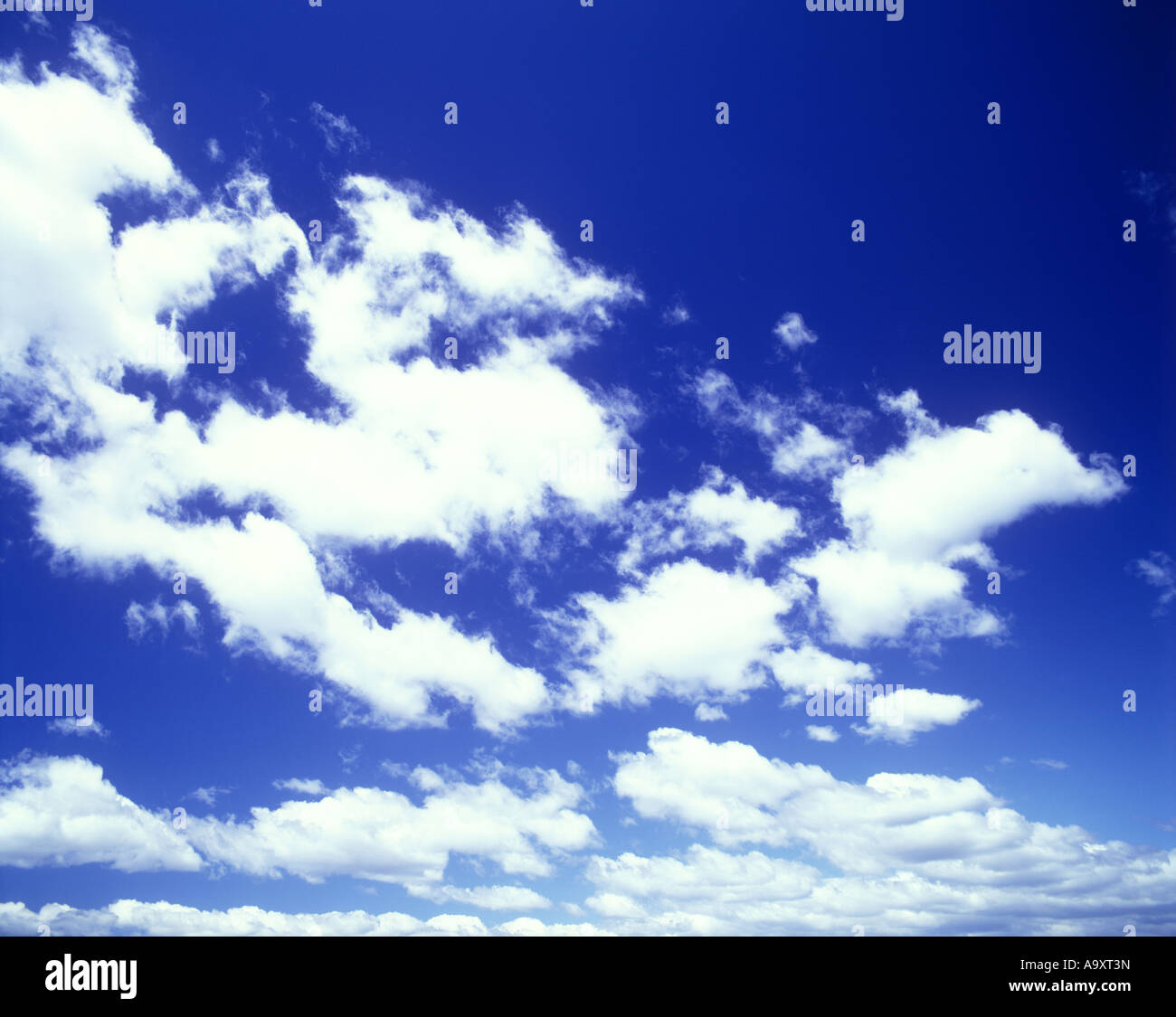 CLOUDSCAPE OF WHITE PUFFY CLOUDS ON PLAIN BLUE SKY Stock Photo - Alamy