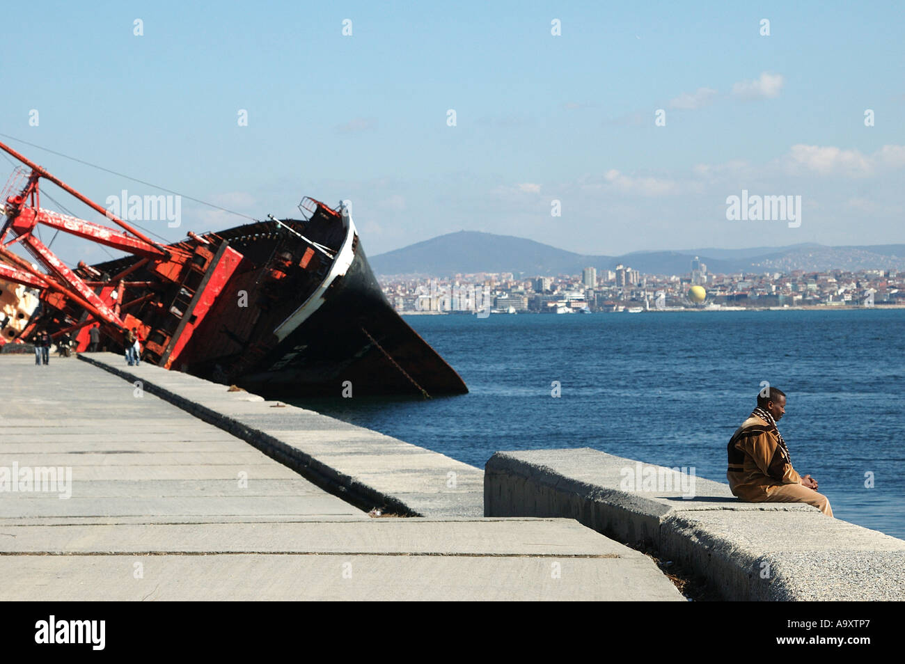 A man stares out to sea next to a sunken freighter in the Sultanahmet area of Istanbul, Turkey Stock Photo