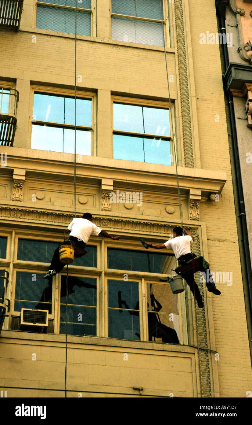 Two balletic suspended window cleaners in San Francisco CA USA Stock Photo