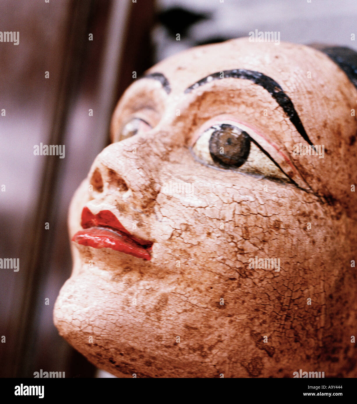 painted carved female wooden head with large eyes Stock Photo