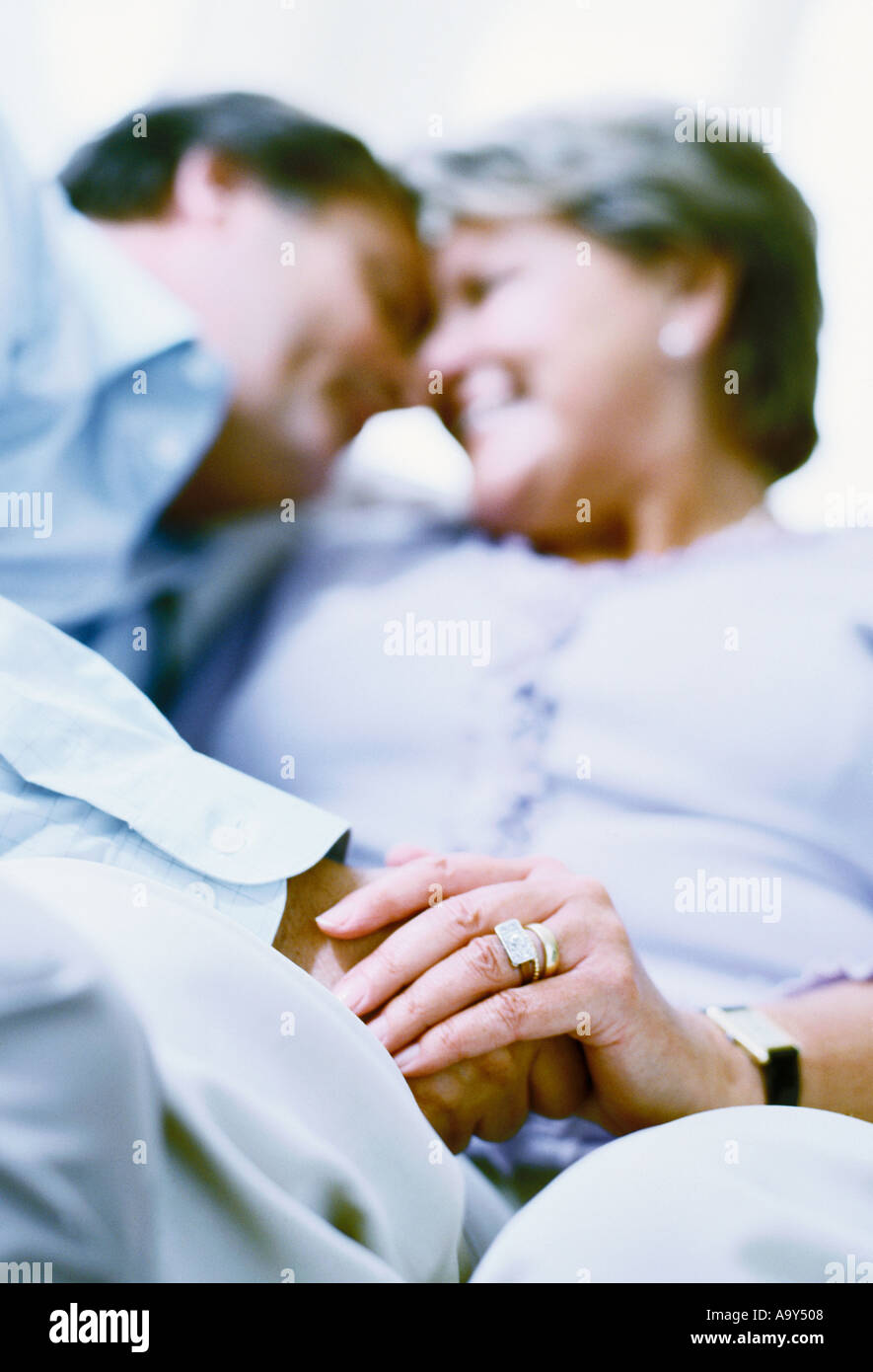 middle aged couple embracing on sofa Stock Photo