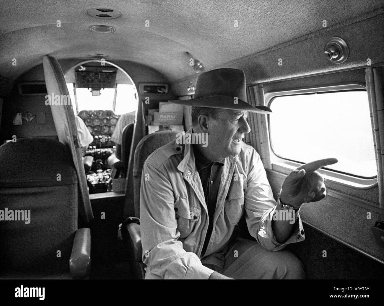 JOHN WAYNE in his private plane on the way to his cotton