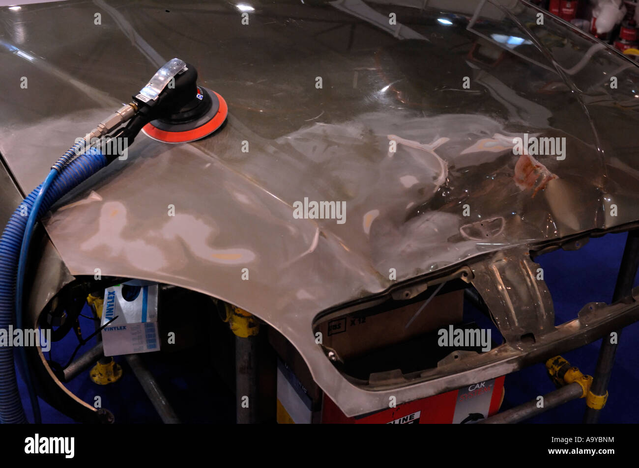 Pneumatic orbital palm air sander on a car hood in a repair shop Auto workshop repairshop tool Stock Photo
