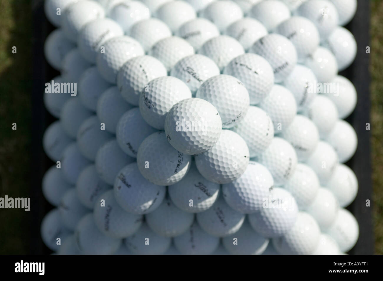 Golf balls set up in a pyramid on a practice range. Stock Photo