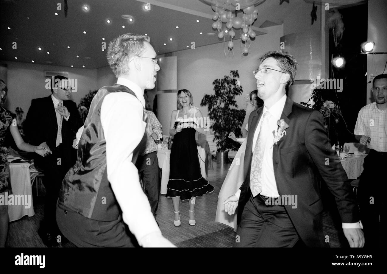 Poland, Lodz, groom dancing with friends at wedding party (B&W) Stock Photo