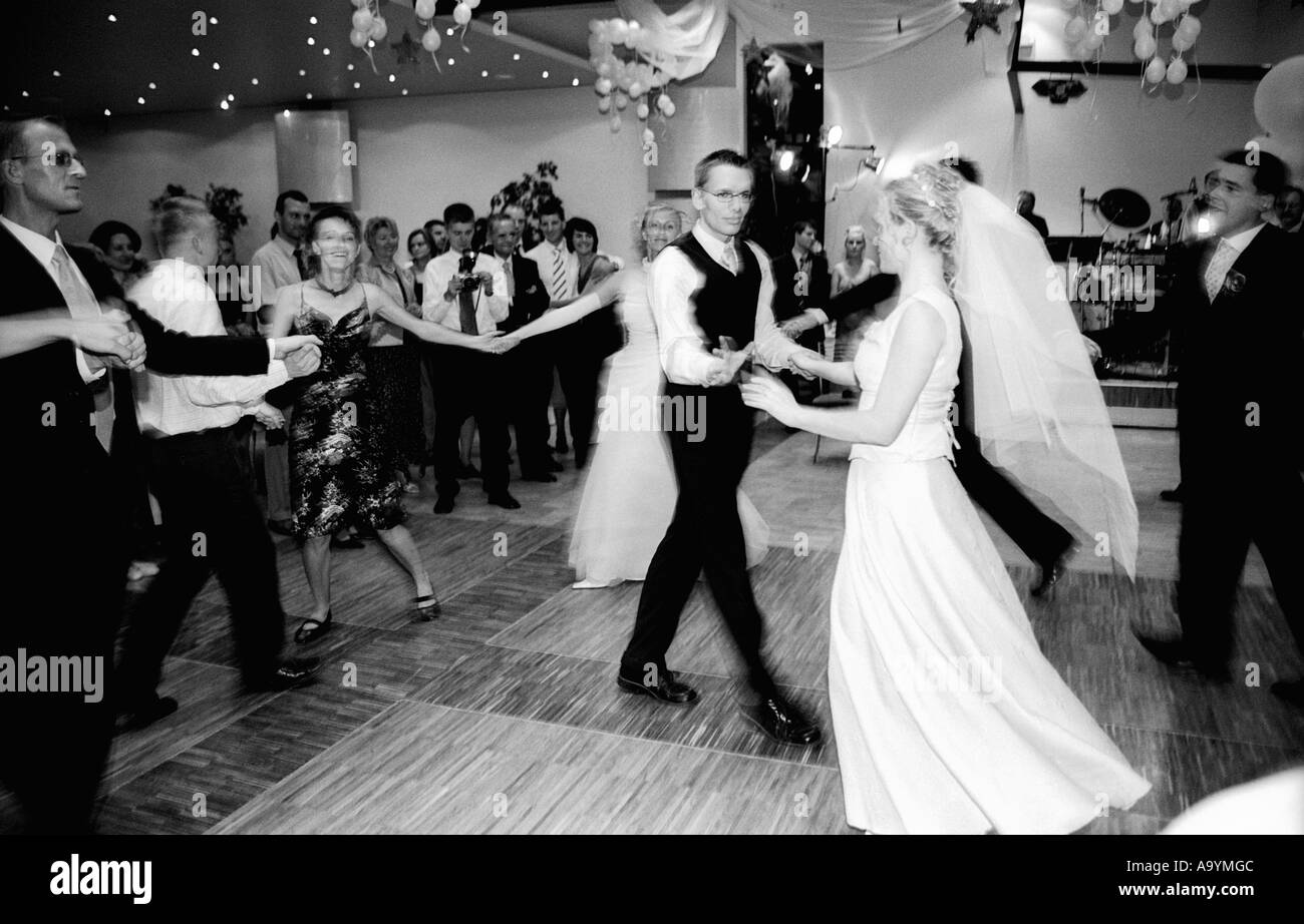 Poland, Lodz, bride and groom dancing with guests at wedding party (B&W) Stock Photo