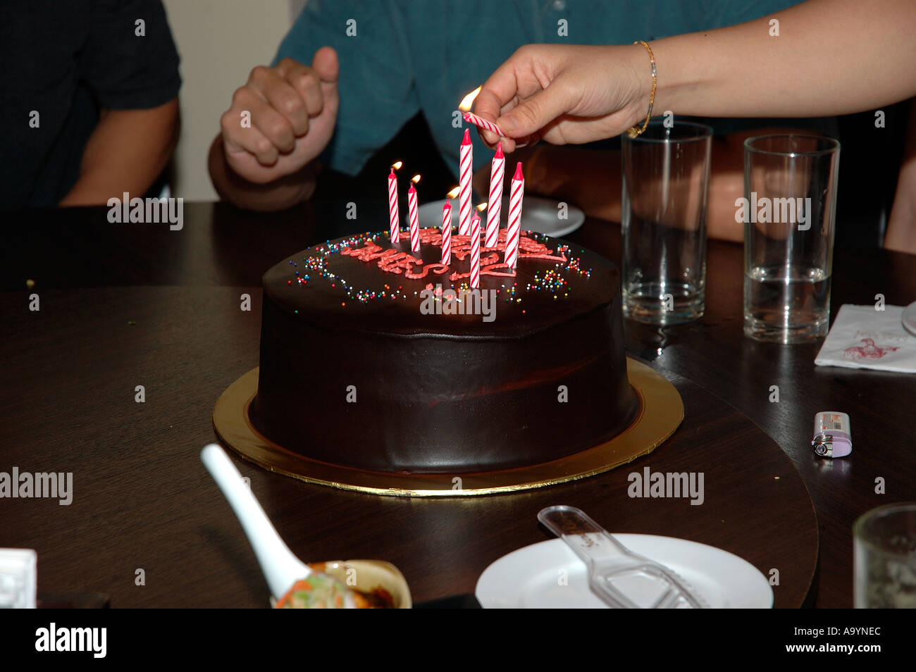 Lighting up birthday candle Stock Photo Alamy