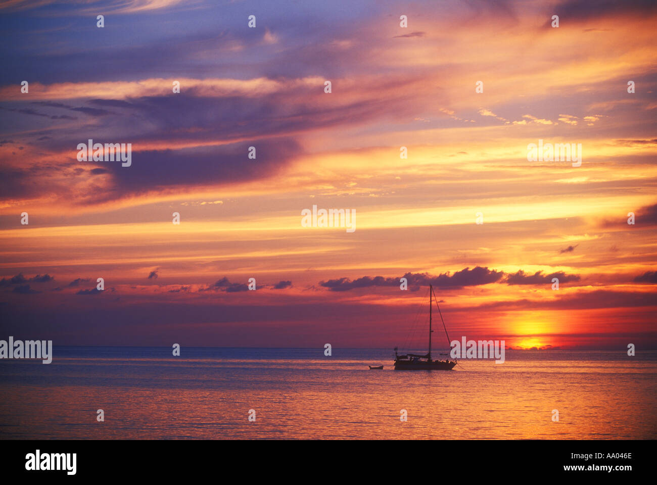 Evening sunset view of sailboat at anchor near the island of Grand Cayman in the Caribbean Stock Photo