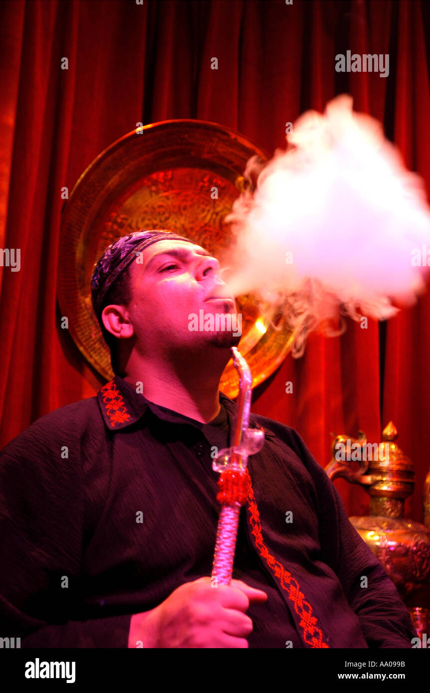 man smoking traditional water pipe in a café Stock Photo
