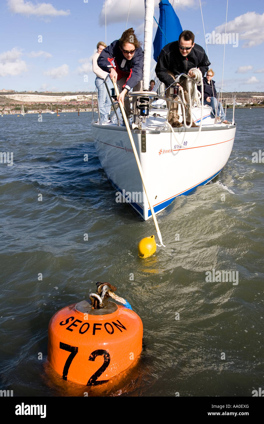 Sailing instruction picking up a mooring buoy in Portsmouth Harbour