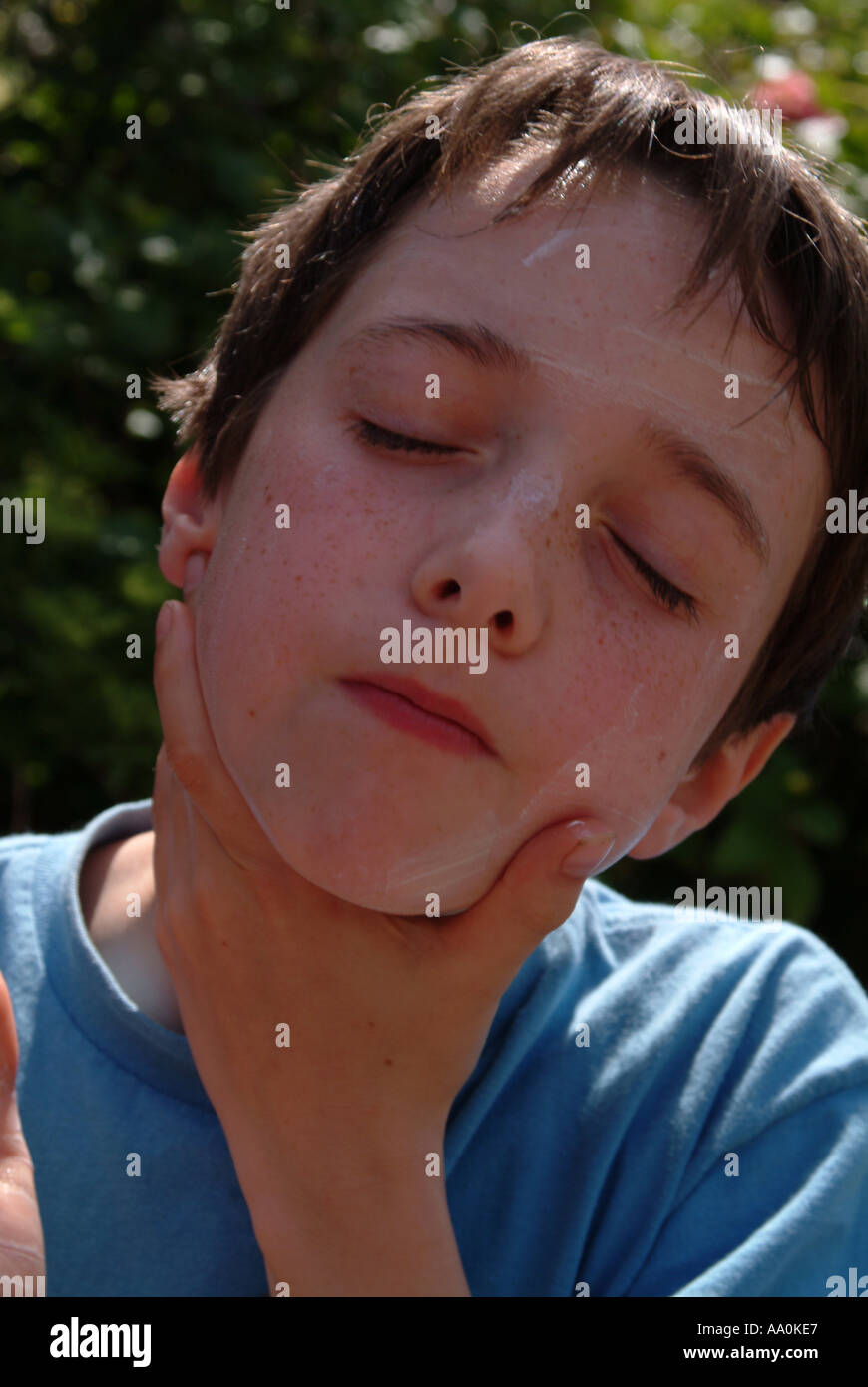 Young boy applying sunscreen to his face Stock Photo Alamy