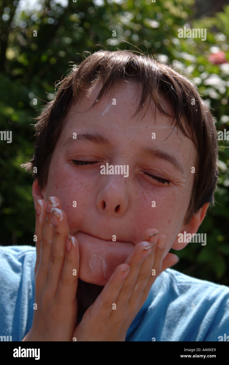 Young boy applying sunscreen to his face Stock Photo Alamy