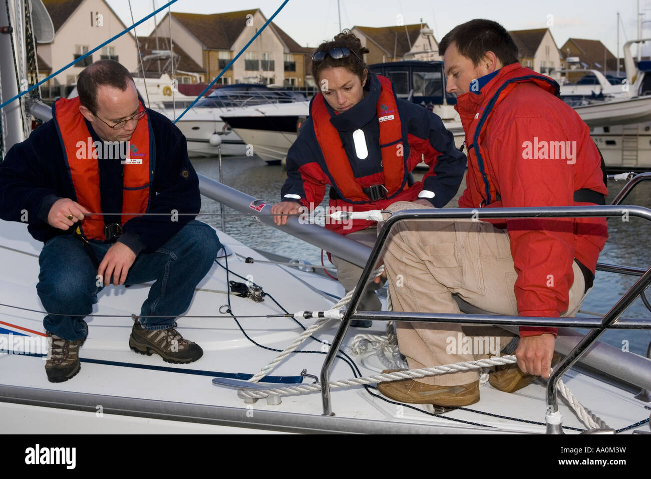 Crew sitting on yacht alongside in Port Solent Marina Portsmouth England Stock Photo