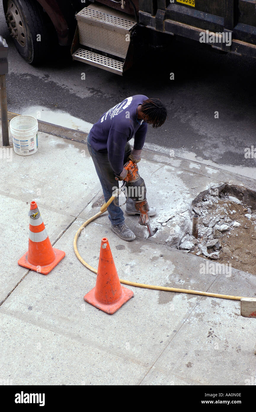 Worker uses jackhammer to break up concrete sidewalk Stock Photo Alamy