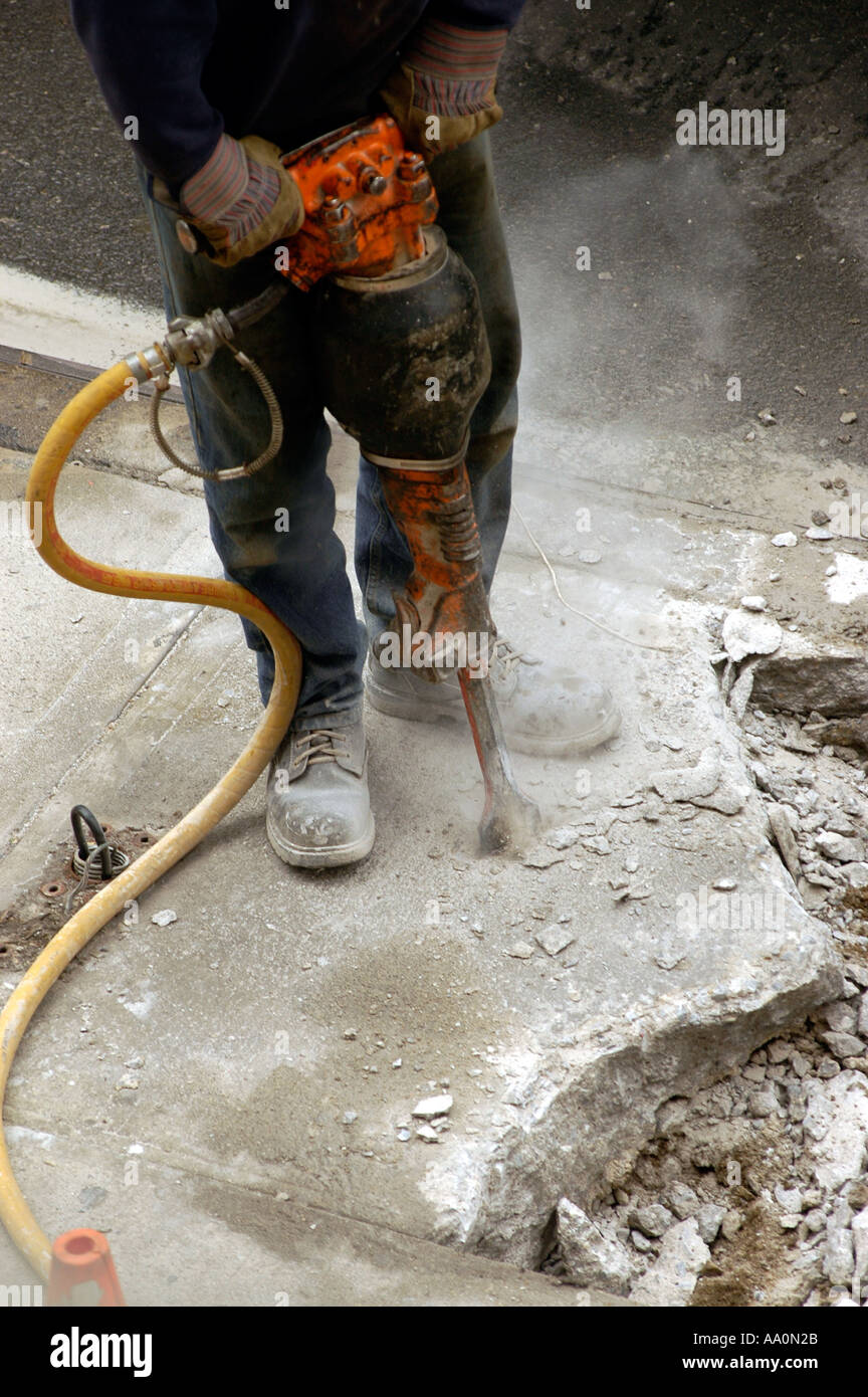 Worker uses jackhammer to break up concrete sidewalk Stock Photo Alamy