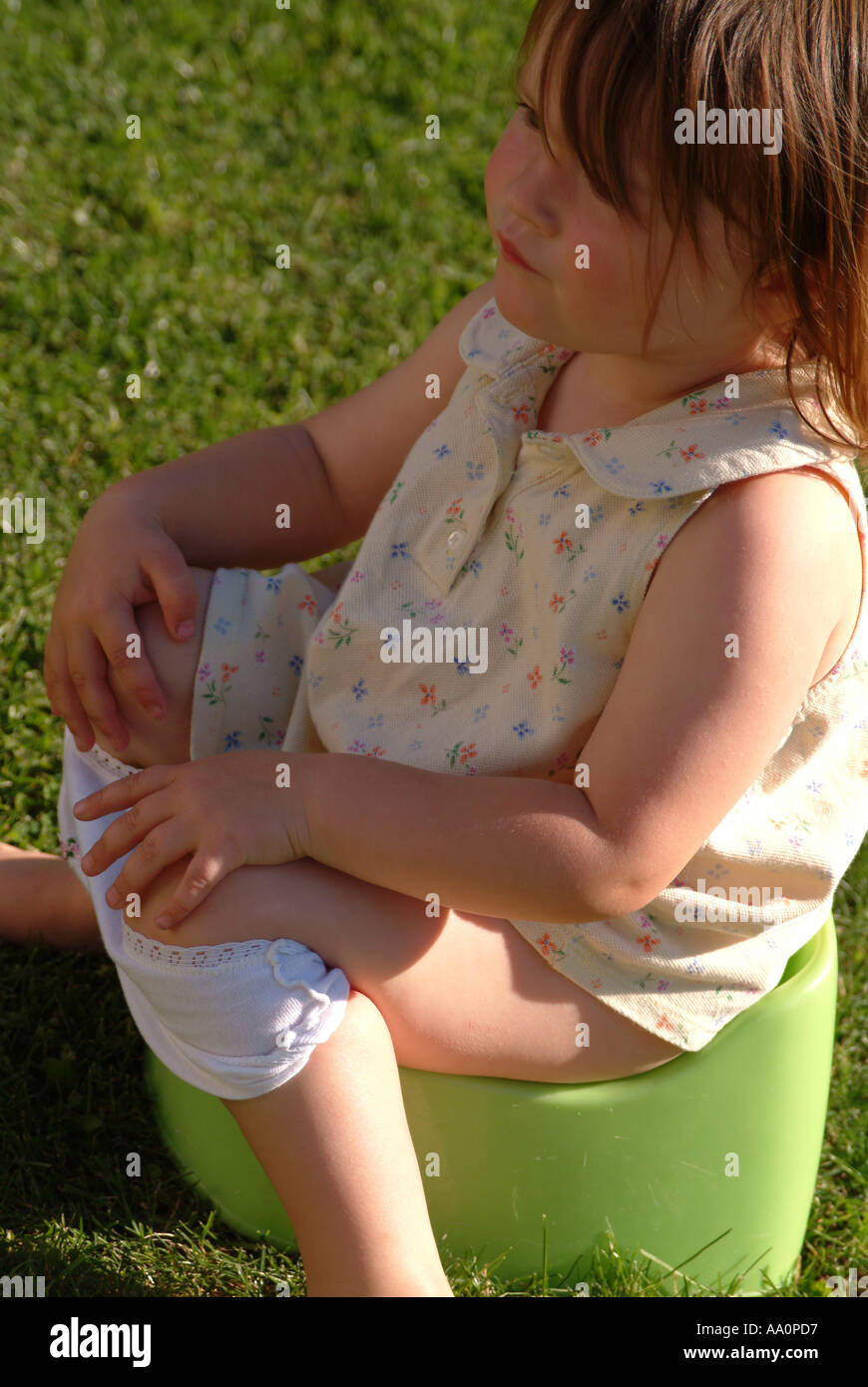 Toddler sitting on a potty outside in the garden Stock Photo Alamy