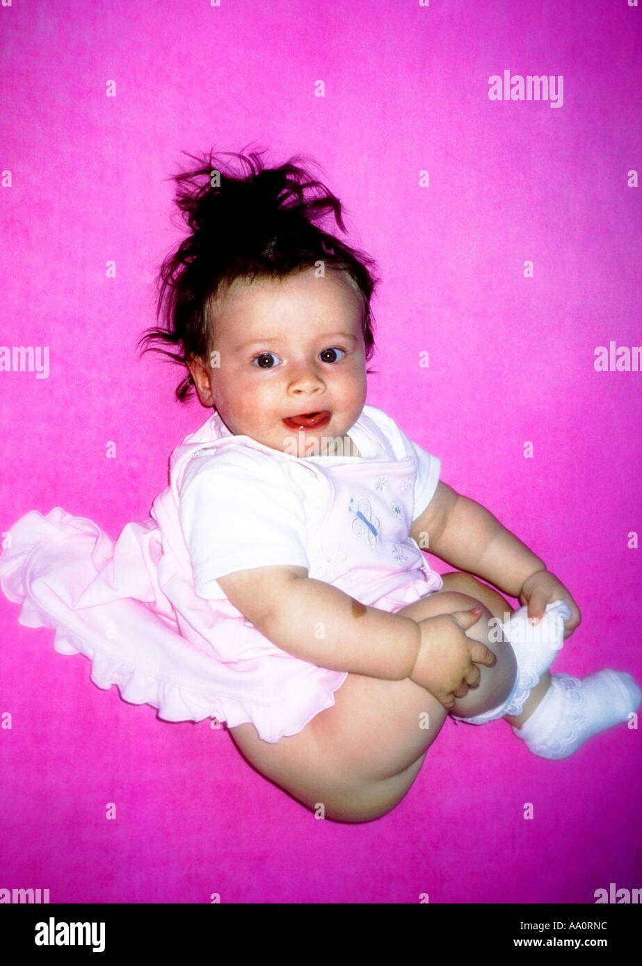 Poland, baby girl (6-9 months) on pink background Stock Photo