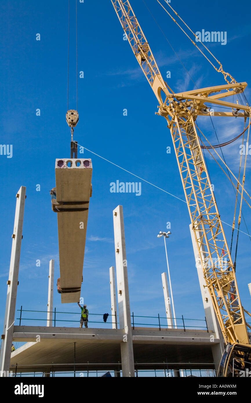 Crane lifting large concrete beam on a construction site Stock Photo