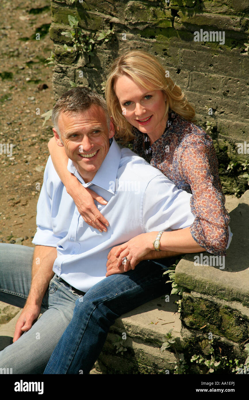 Happy middle aged couple sitting on steps Stock Photo