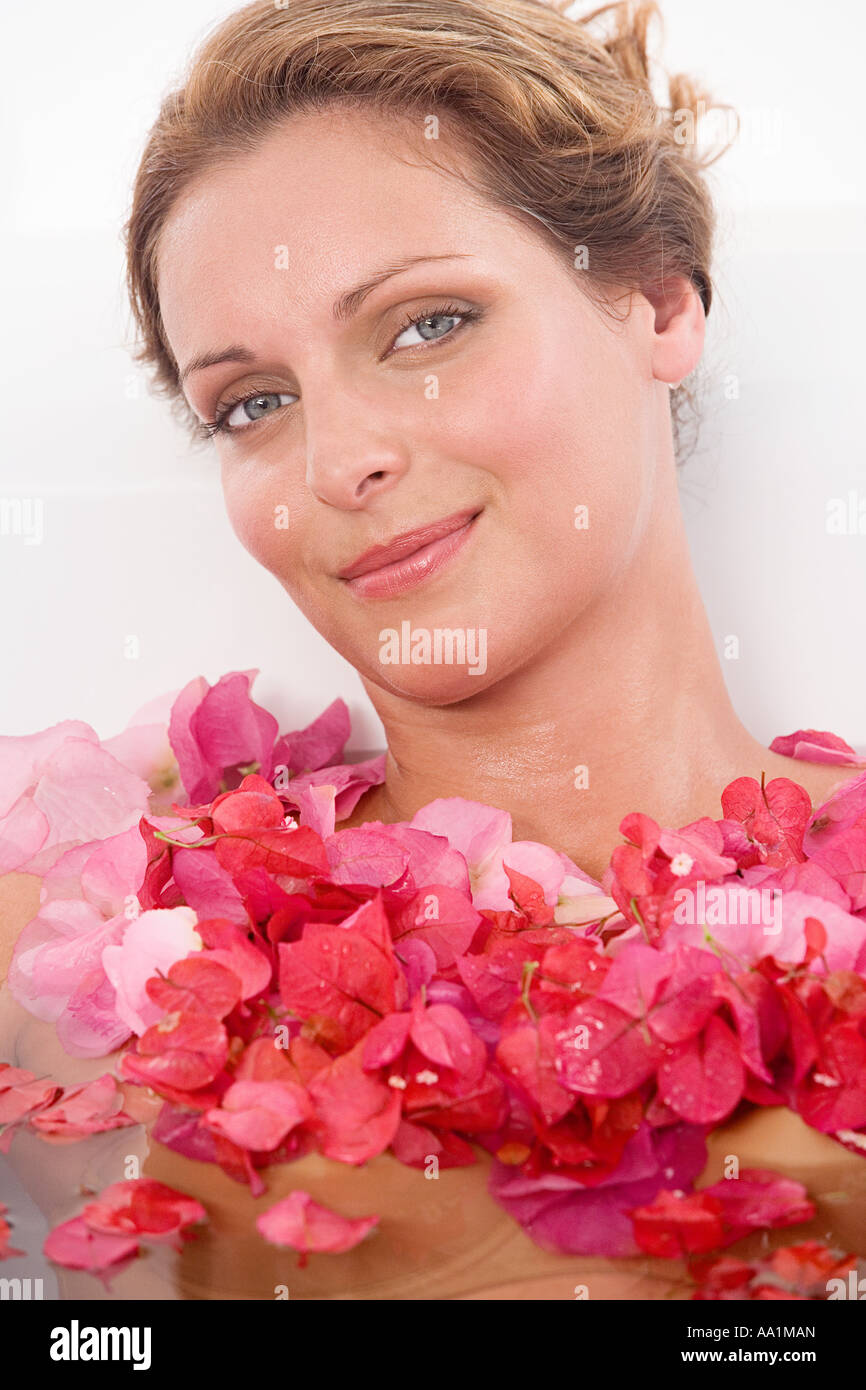 Woman in a bath with petals Stock Photo