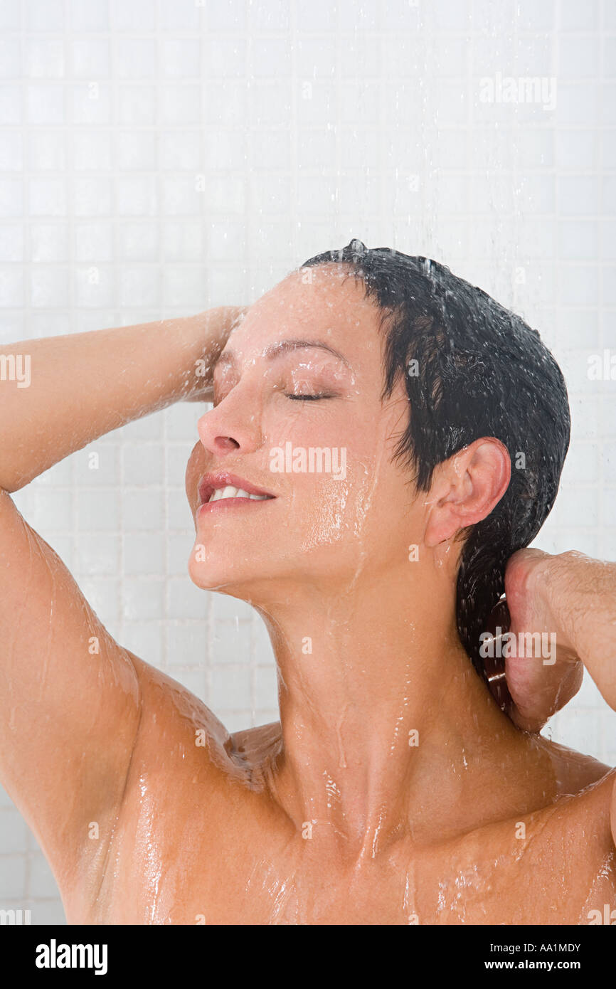 Smiling young girl bathing under a shower at home. Beautiful teen girl  taking shower and washing in the bathroom. Happy child washing head, face  and body with water. Stock Video