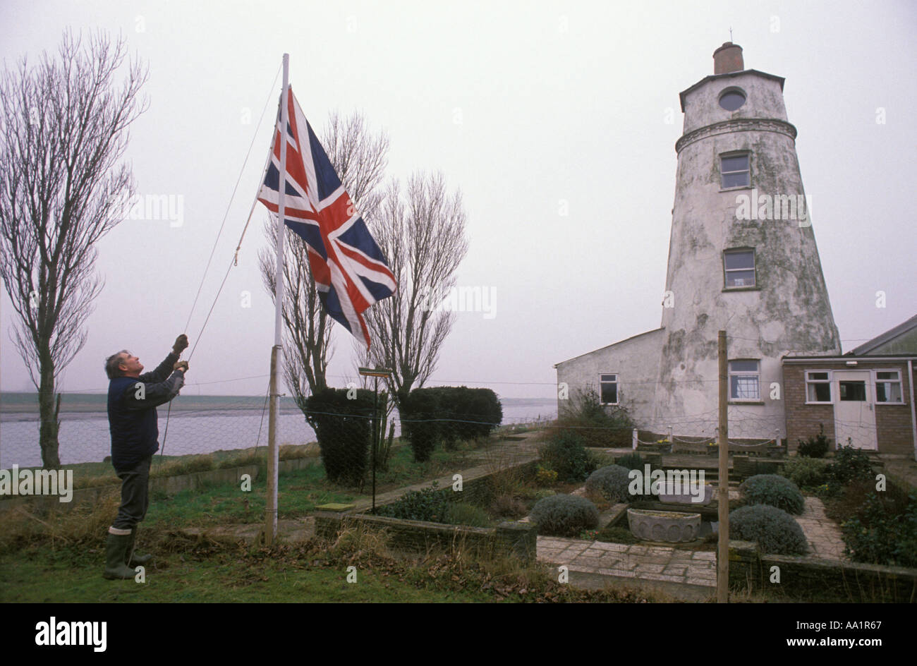 Living in a Lighthouse. East Light lighthouse Sutton Bridge, Lincolnshire. Commander David Joel raises Union flag every morning. 1990S UK  HOMER SYKES Stock Photo