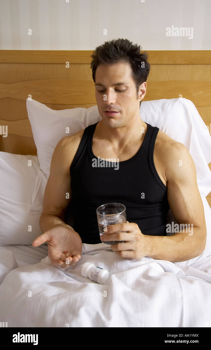 Man in Bed, Taking Pills Stock Photo - Alamy