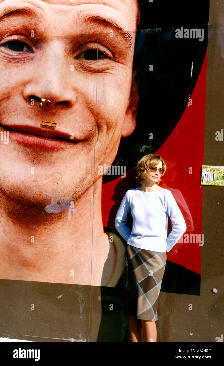 France, Paris, young woman posing by billboard with smiling man Stock Photo