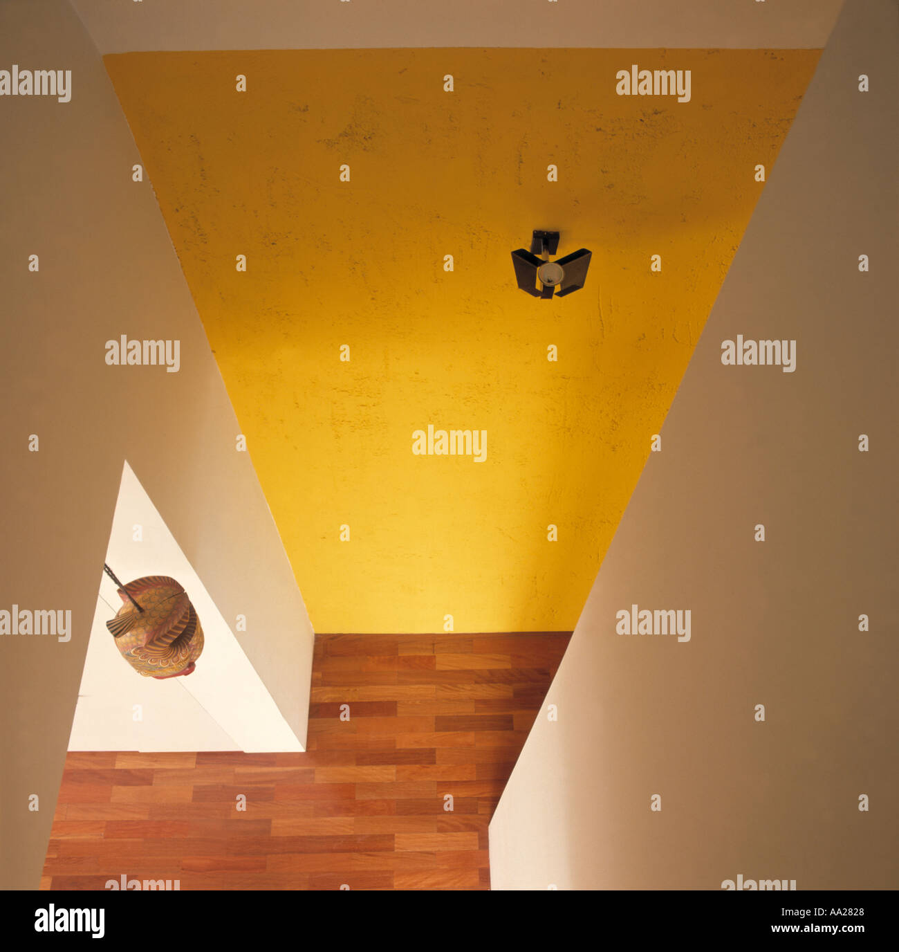 Birds-eye view of bright yellow wall and wood block floor in modern