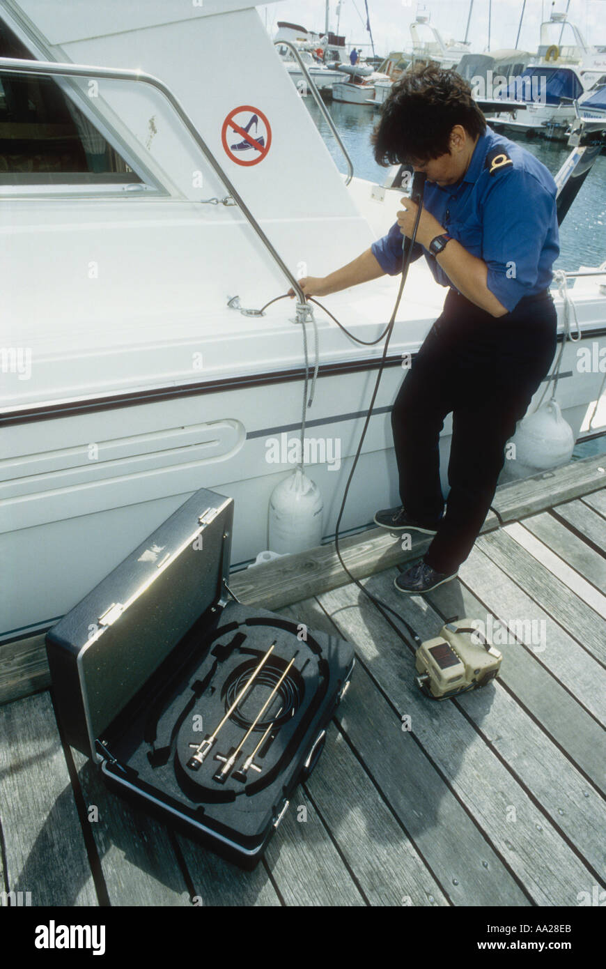 A Customs and Excise officer uses an endoscope to check a cruiser water tank for hidden drugs Poole Dorset England UK Stock Photo