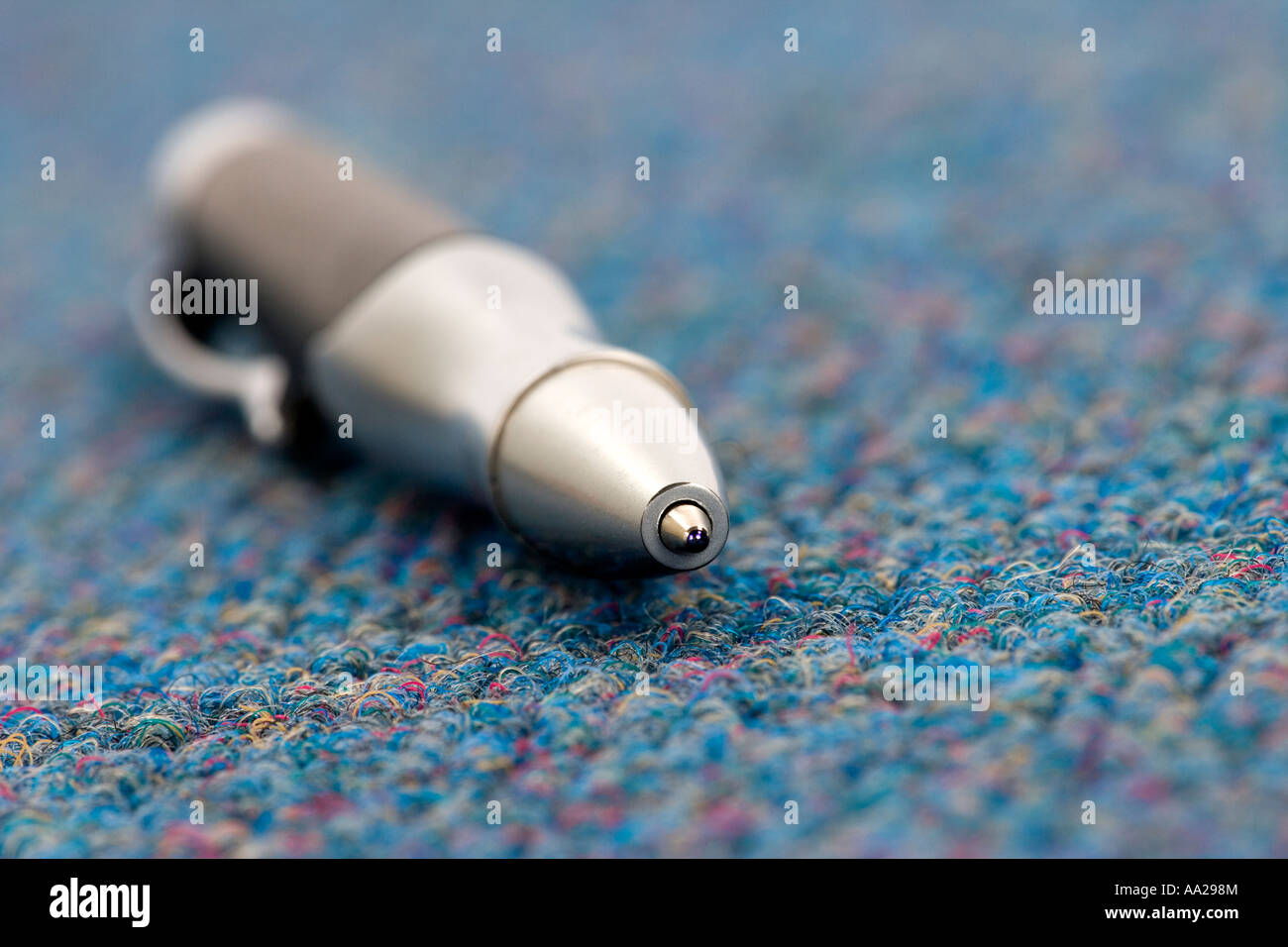 Ball point pen nib concept on blue carpet floor close up Stock Photo