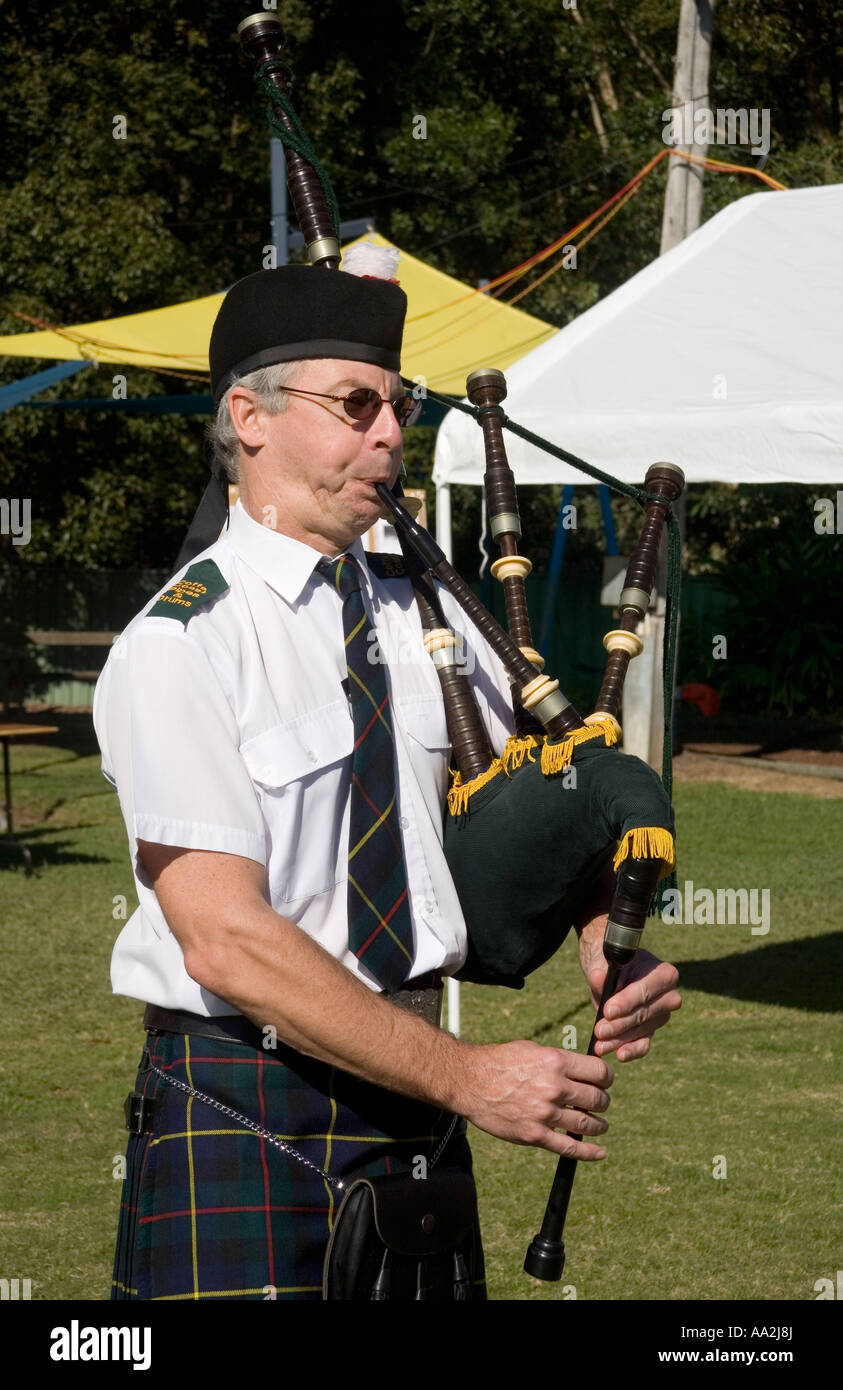 a man playing bagpipes and wearing traditional costume Stock Photo