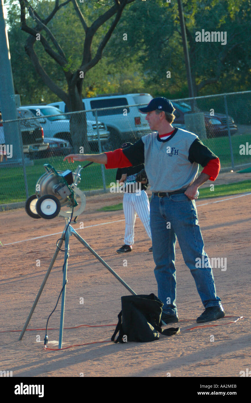 Baseball Coach with Pitching Machine Stock Photo Alamy