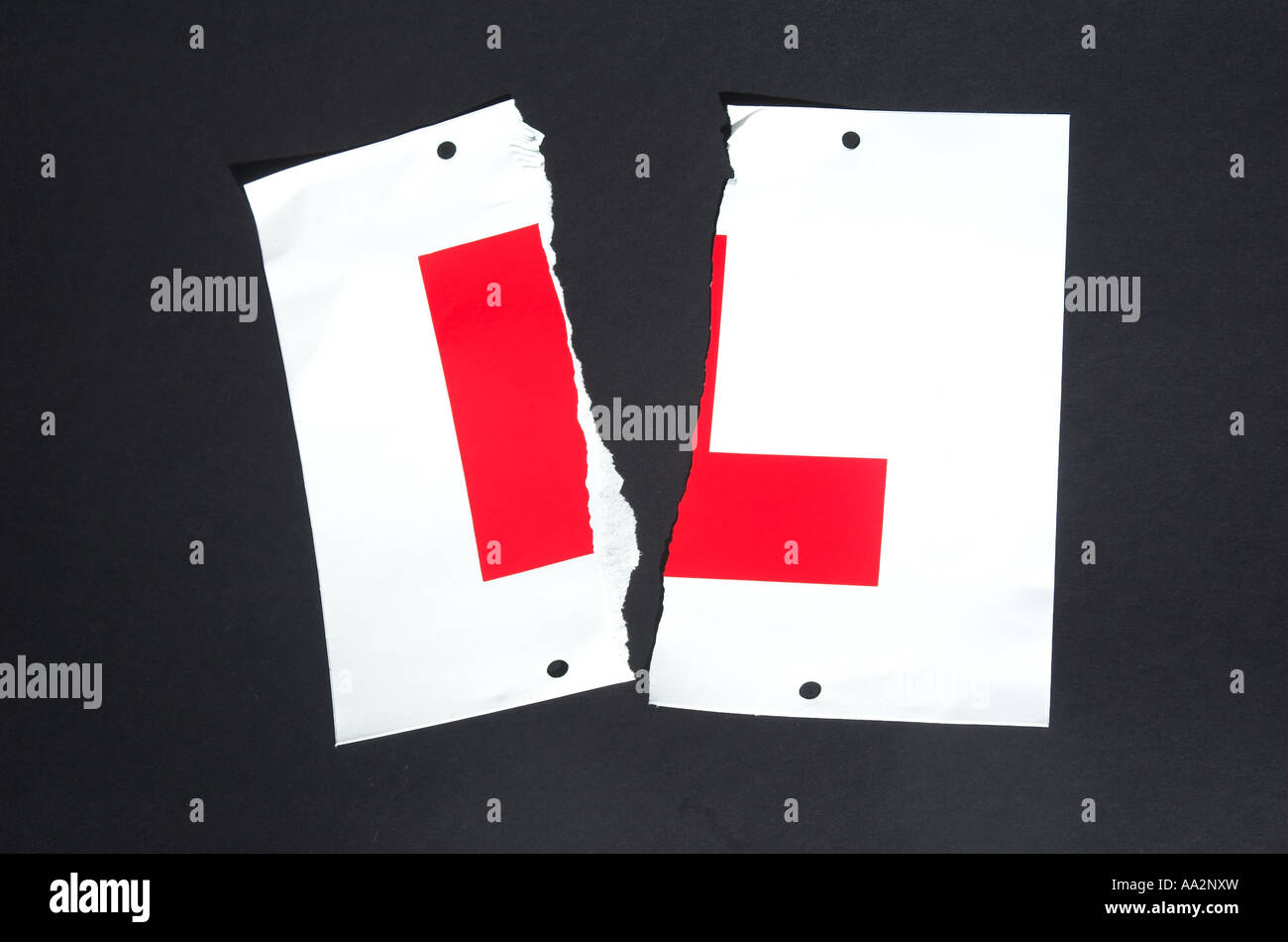 Learner L plates against black background torn into two Stock Photo