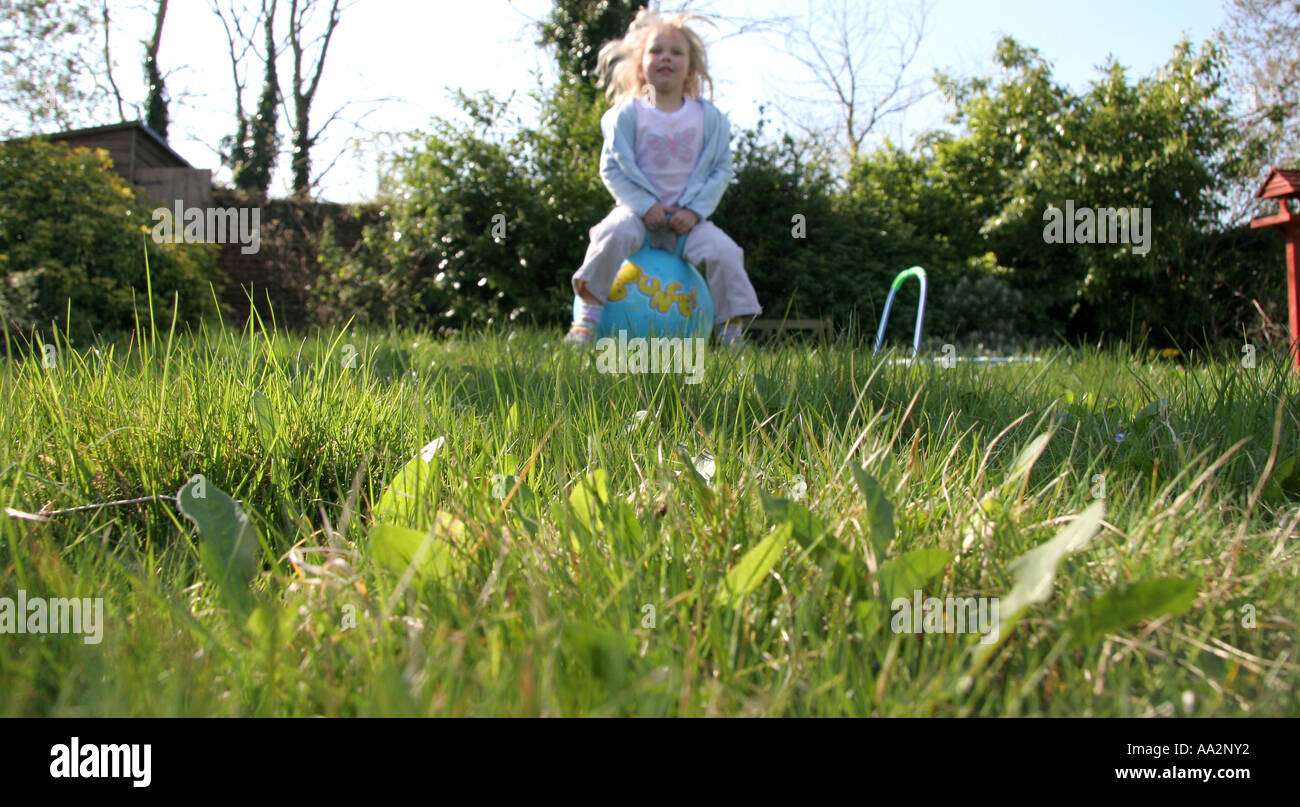 young girl on space hopper in garden Stock Photo