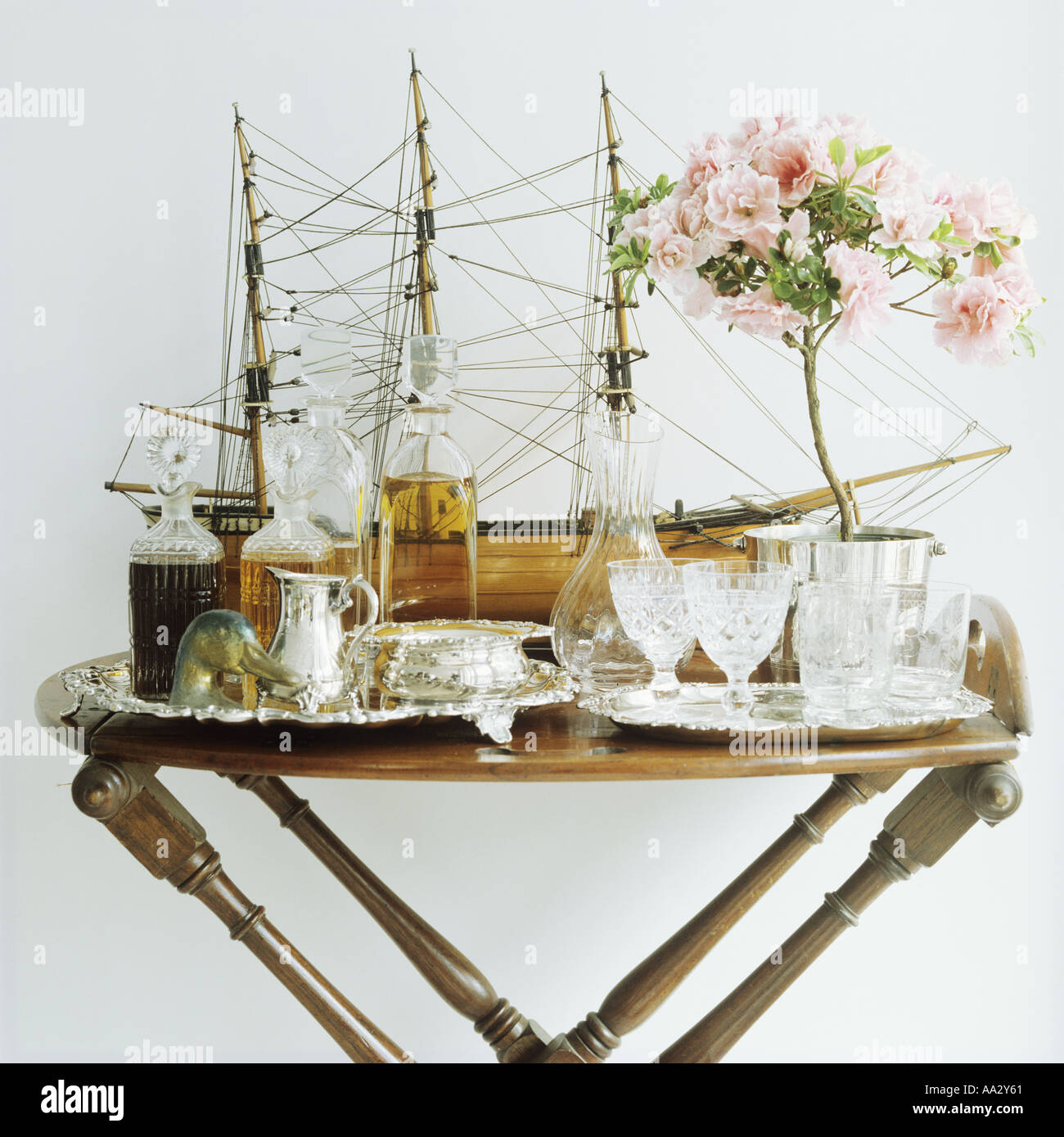 Close-up of model sailing antique tray-table with antique cut-glass decanters and glasses on silver trays Stock Photo