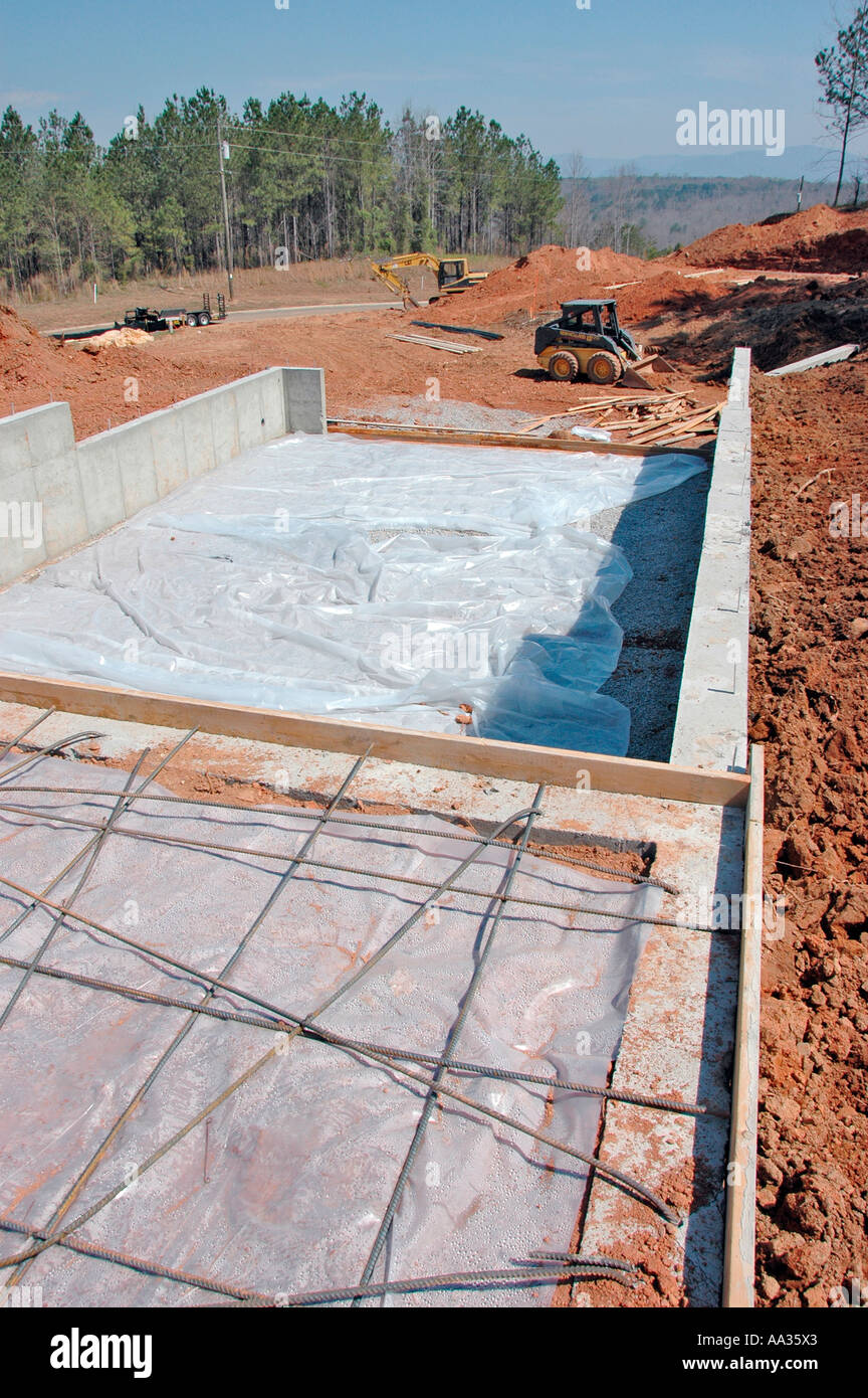 Bobcat dirt work around new foundation for new home construction Stock
