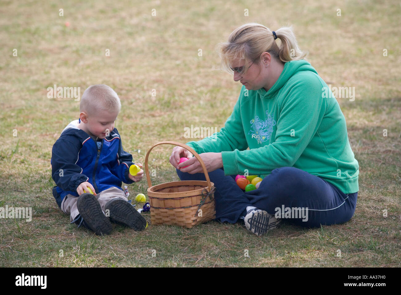 Mother and baby enjoy candy after an easter egg hunt, New England, USA Stock Photo