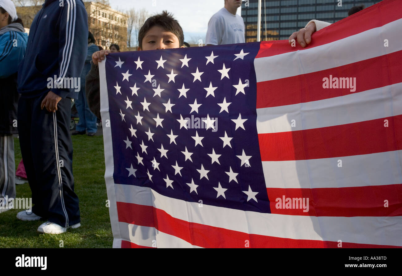 A small boy behind a USA Flag at an Immigration Rally Stock Photo