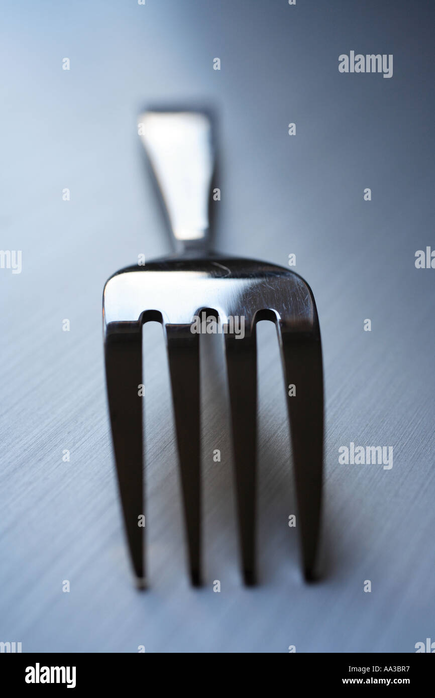 Single "fork" on stainless steel kitchen work surface Stock Photo