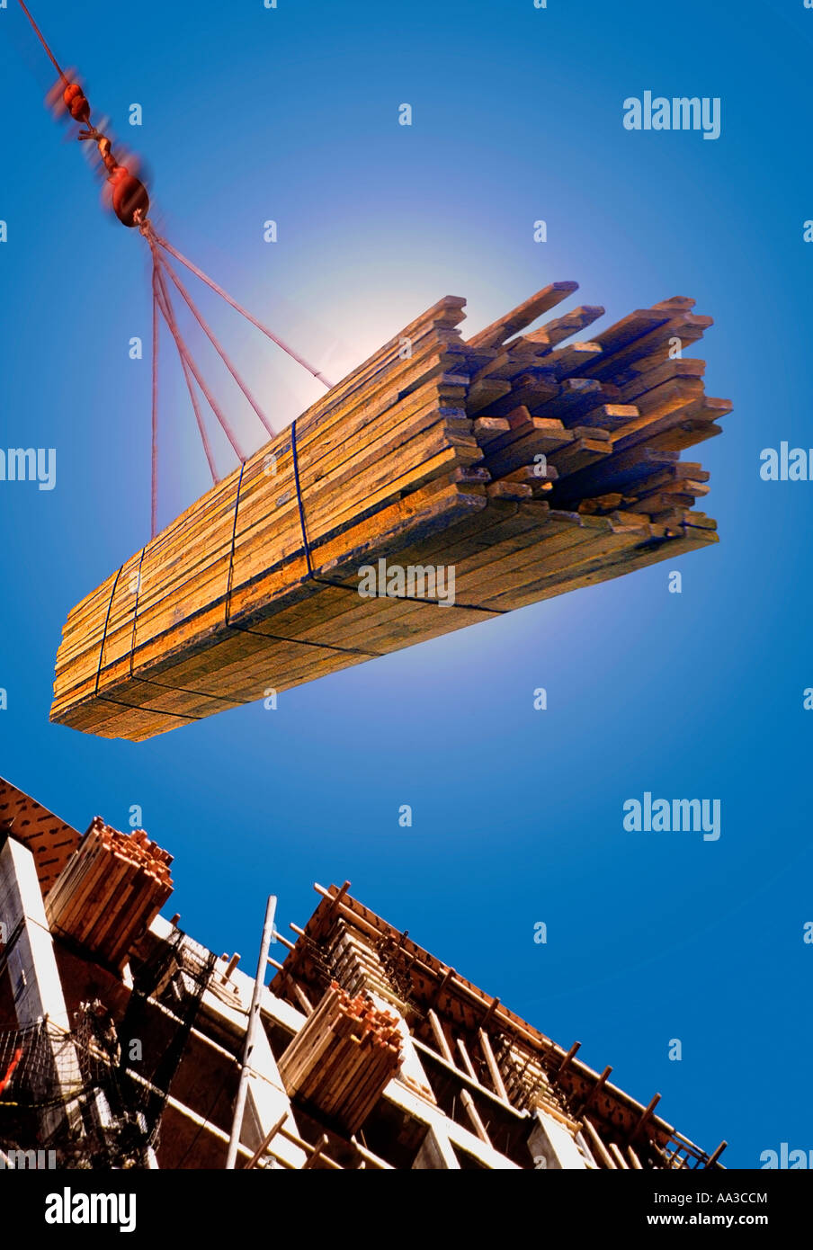 Construction site. Industrial equipment, heavy duty crane hoisting wood ...