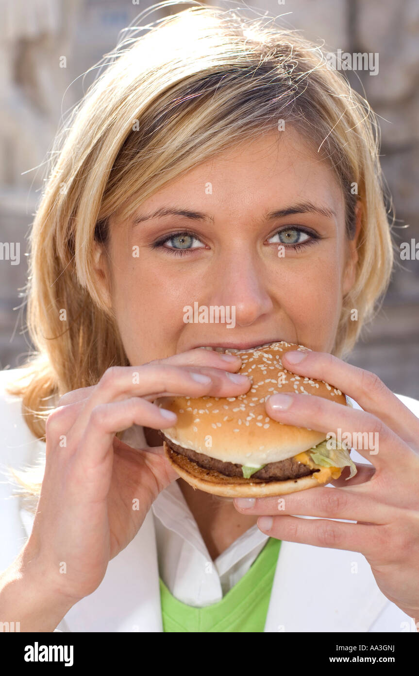 young woman eating an hamburger Stock Photo - Alamy