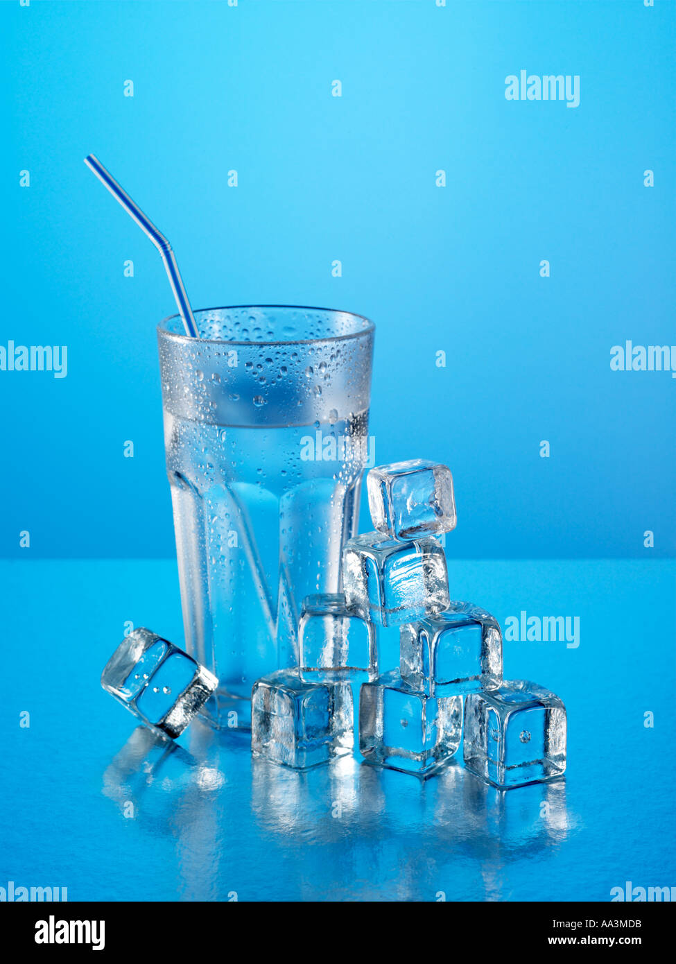 Glass of refreshing water with ice cubes and straw Stock Photo - Alamy