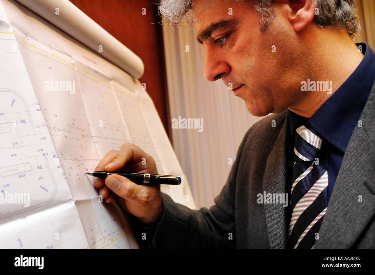 Male architect or engineer working on blueprints Stock Photo