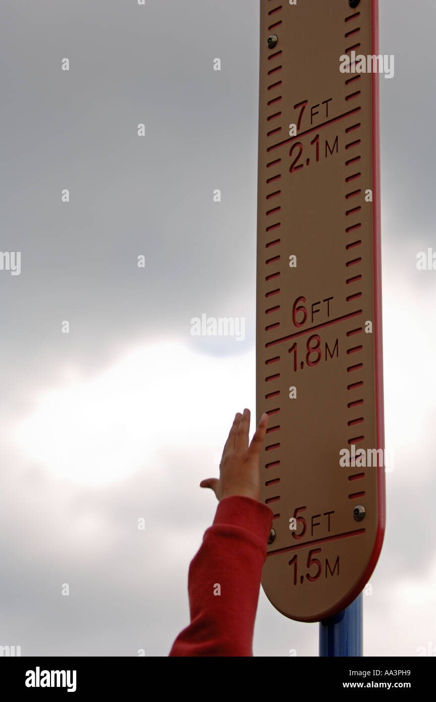 Young boy jumping and measuring the height of his jump on a ruler board