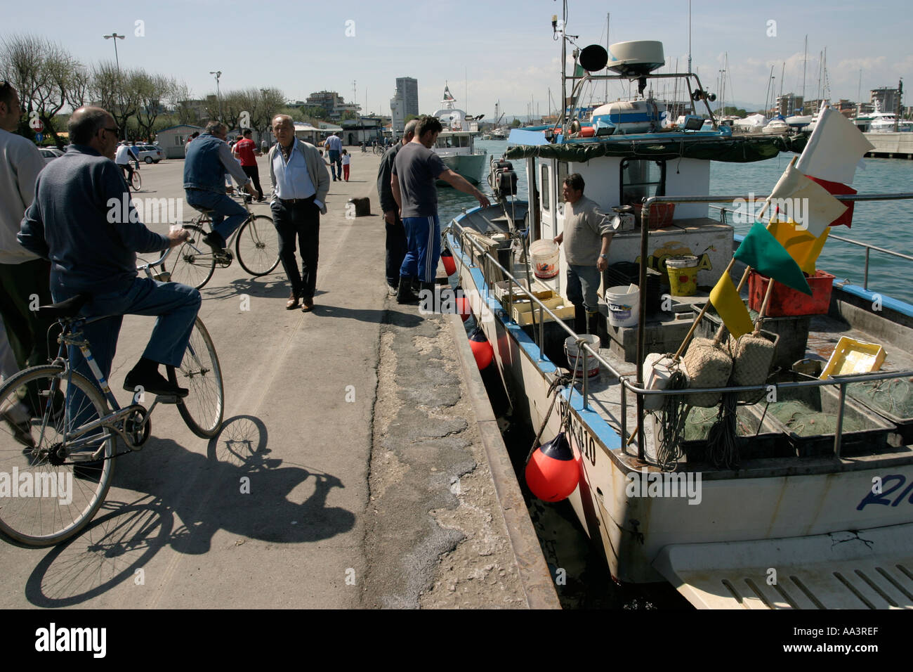 Customer buying fresh fish from a fisherman fresh fish being unloaded in the port of Rimini in